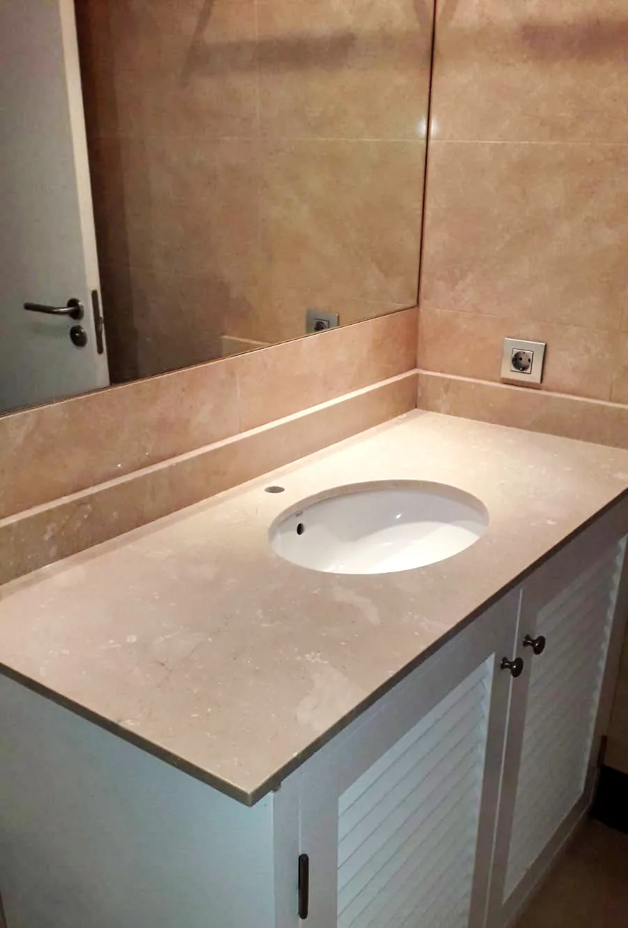 Detalle de lavabo sobre encimera de piedra